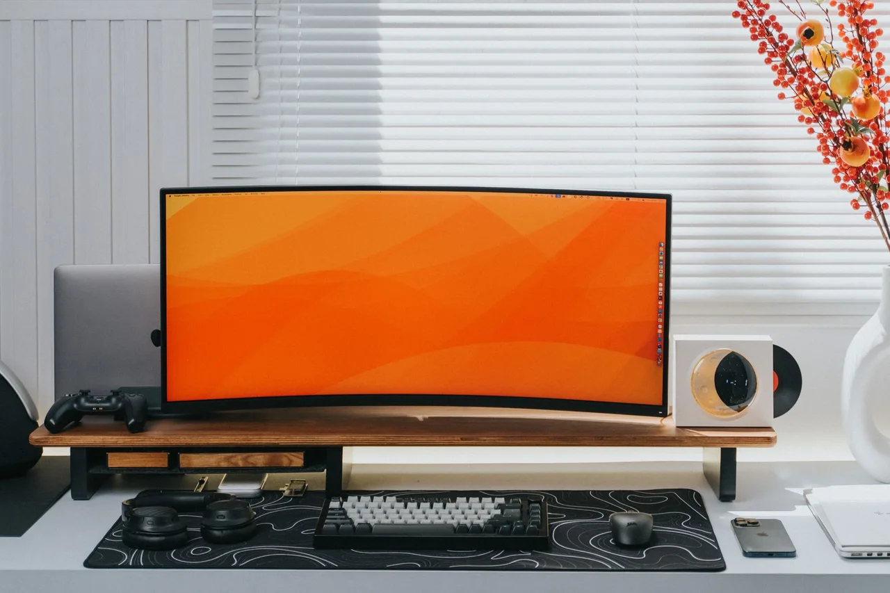 A curved computer monitor on a neatly arranged desk