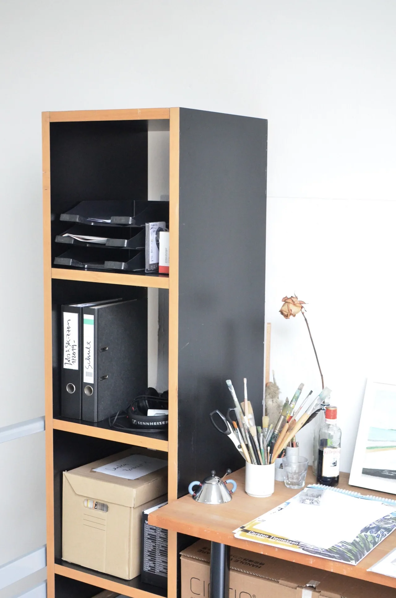 Office shelves holding folders and boxes above a work surface