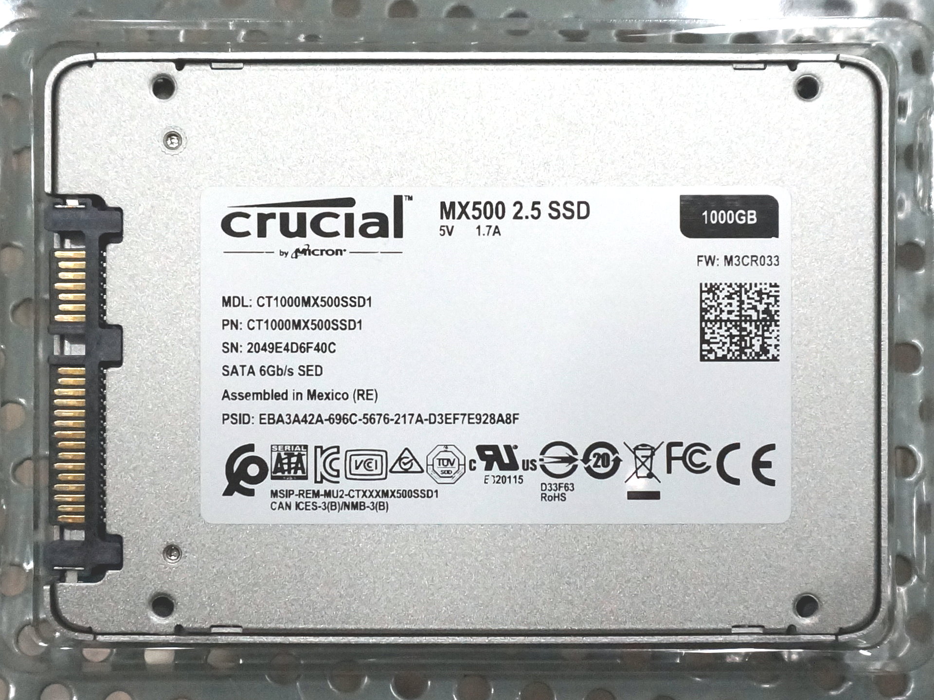 Authentic rear photograph of Crucial MX500 1 TB 2.5-inch SATA SSD with exact CT1000MX500SSD1 and 1000GB label