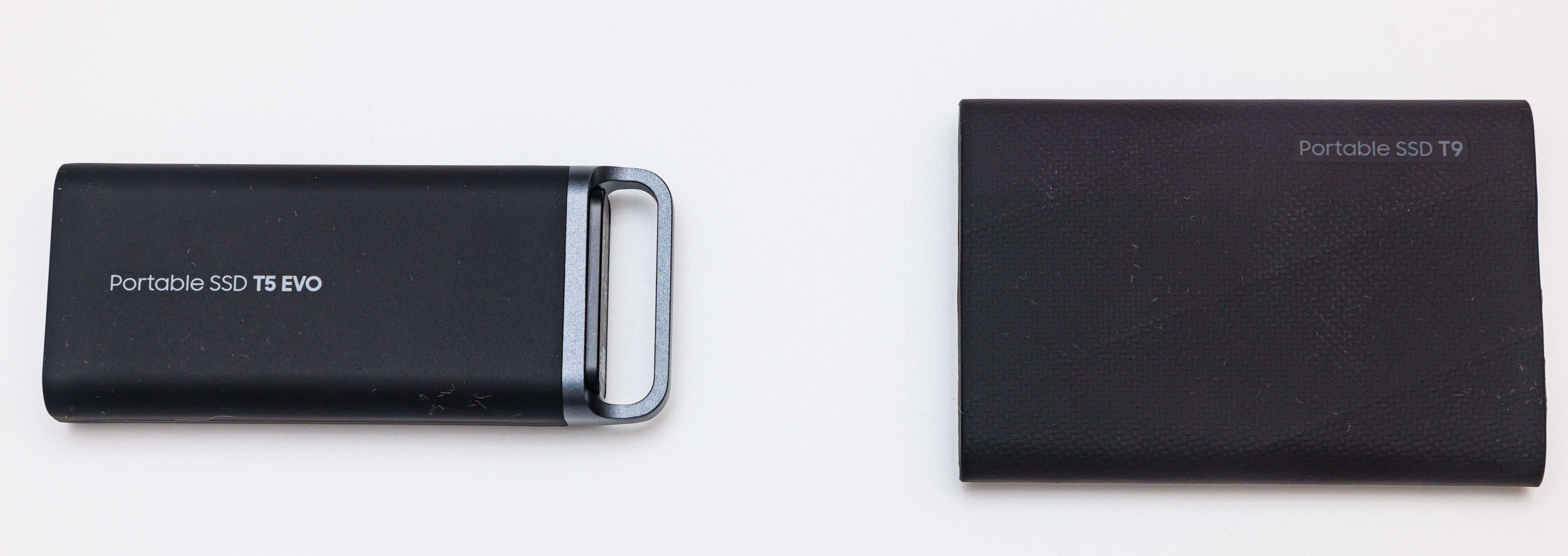 Authentic black Samsung T9 at right beside a separate T5 EVO comparison drive, rear view